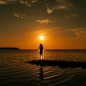 Silhouette einer Frau im goldenen Sonnenlicht, kraftvoll und ruhig - Symbol für Entscheidung und ein Leben im Einklang