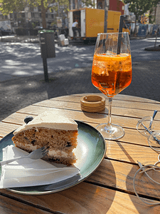 Schöne Momente mit Kuchen und Aperol Spritz Ein Stück Kuchen und ein Aperol Spritz - schöne Momente genießen