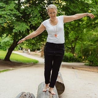 Foto von Jana Engel balancierend auf Baumstamm