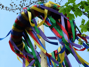 Bunte Bänder wehen am Maibaum im Frühlingslicht – Symbol für Fruchtbarkeit, Freude und Lebenskraft zu Beltane