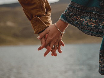 Beltane – Hände, die sich finden Zwei Menschen halten sich sanft an den Händen – Sinnbild für Verbindung, Liebe und Neubeginn zu Beltane