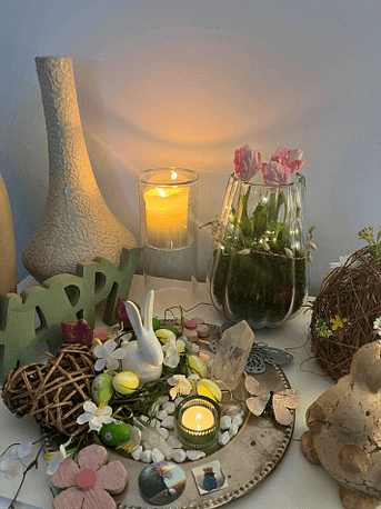 Ostara-Altar mit Blüten, Kerzen und Symbolen Ein liebevoll gestalteter Frühlingsaltar mit Kerzen, Blüten, Kristallen, Hasenfigur und Dekoration für Ostara