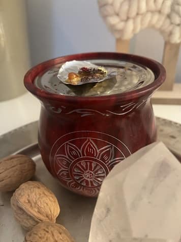 Rituale in den Rauhnächten - Ein Räucherstövchen mit Altarobjekten wie Bergkristall und Nüsse