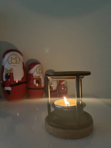 Ein kleines Räucherstövchenn mit sanfter Flamme - Symbol für Ruhe und Bereinigung in den Rauhnächten