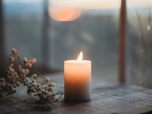 yule-wintersonnenwende-jule-keltischer-jahreskreis-rituale-magie-hoffnung-loslassen-neubeginn-bewusste-winterzeit-rauhnaechte-13-wuensche-natur-kerze Kerze vor Fenster