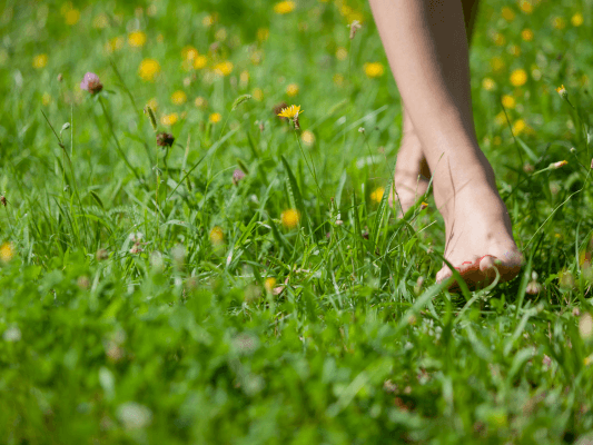Barfuß auf einer blühenden Frühlingswiese – Sinnbild für Beltane, Freiheit und das Erwachen der Sinne