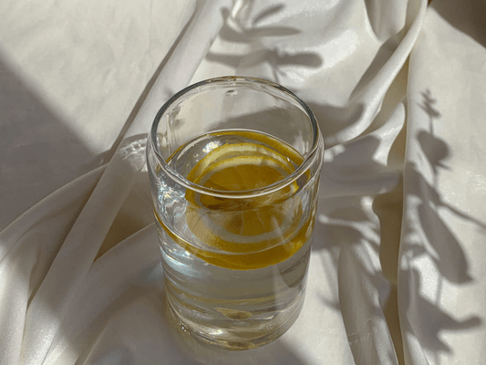 Sonnenwasser-Ritual zur Sommersonnenwende mit Glas, Zitrone und Lichtreflexen