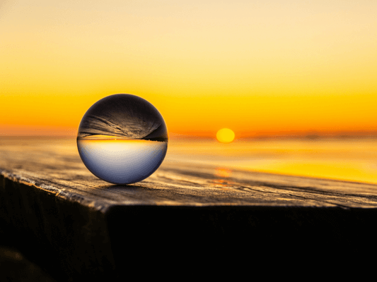 Glaskugel reflektiert Sonnenuntergang - Sinnbild für Selbstreflexion und Human Design als Spiegel auf dem Weg zur Lebensaufgabe