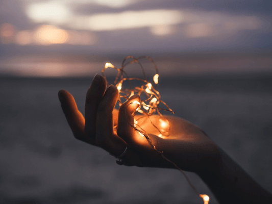 Hand hält eine Lichterkette - die eigene Stimme beginnt zu leuchten
