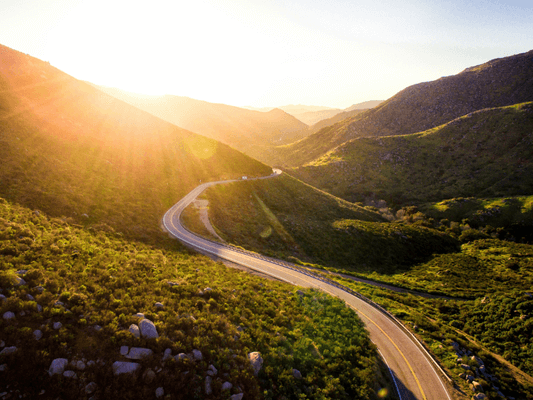 Sich windende Straße im Sonnenlicht - Symbol für den individuellen Weg zur Lebensaufgabe