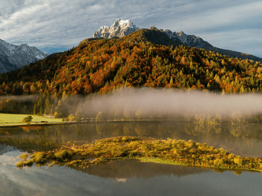 Herbstliche Berglandschaft mit Nebel über dem See Herbstliche Berglandschaft mit Nebel über dem See - Symbol für Schwelle und Übergang zu Samhain
