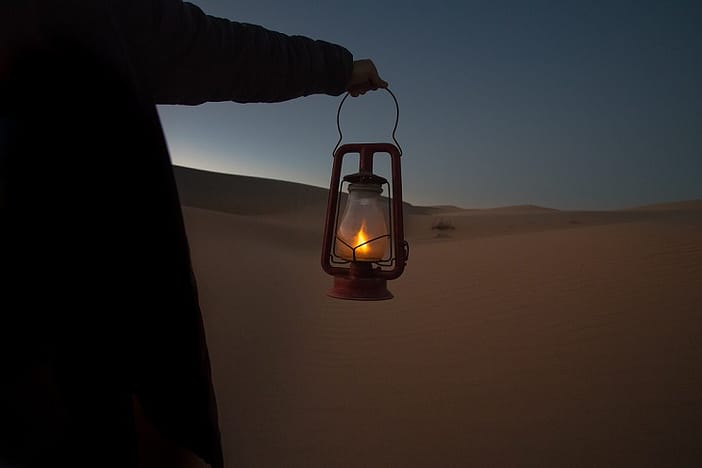 Hand mit Öllampe auf dem Weg durch die Wüste