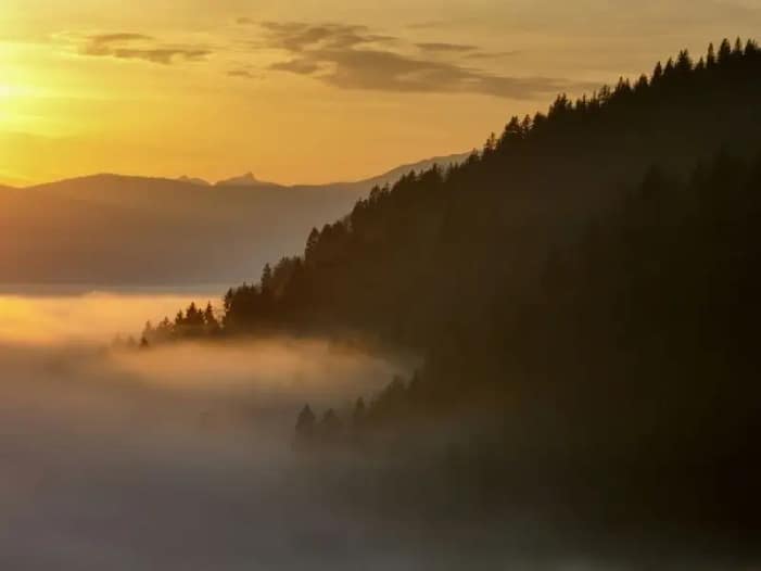 Die AKASHA Chronik - Das Feld Mit Nebel bedeckter Fuß von Berghängen im Sonnenuntergang - Symbol für die AKASHA Chronik als Feld und all den Erfahrungen und Weisheiten darin