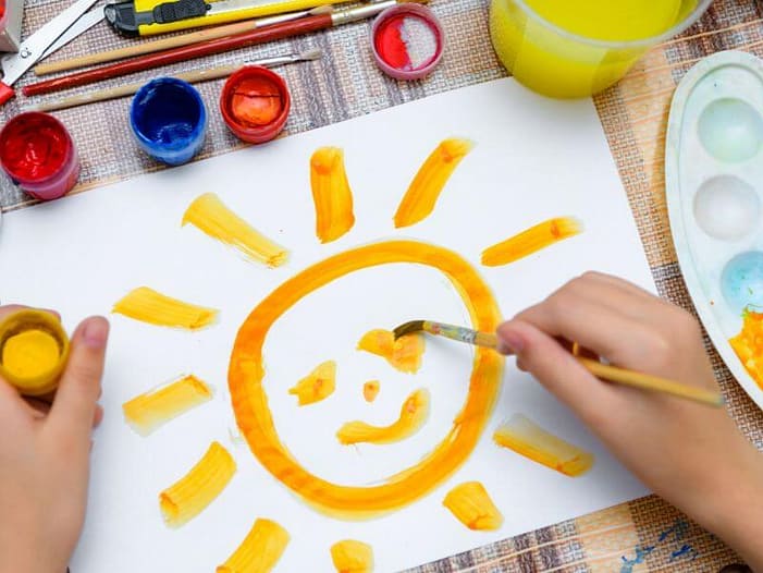 Die Rückkehr des Lichts - kindgerecht gefeiert Kind malt mit Wasserfarben eine Sonne - kreative Yule-Rituale für Kinder zur Wintersonnenwende