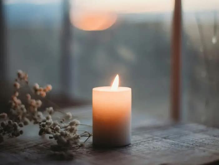 Yule-Kerzenritual zur Rückverbindung mit dem inneren Licht Brennende Kerze als Symbol für das Licht in der Dunkelheit - zentrales Yule-Ritual zur Wintersonnenwende