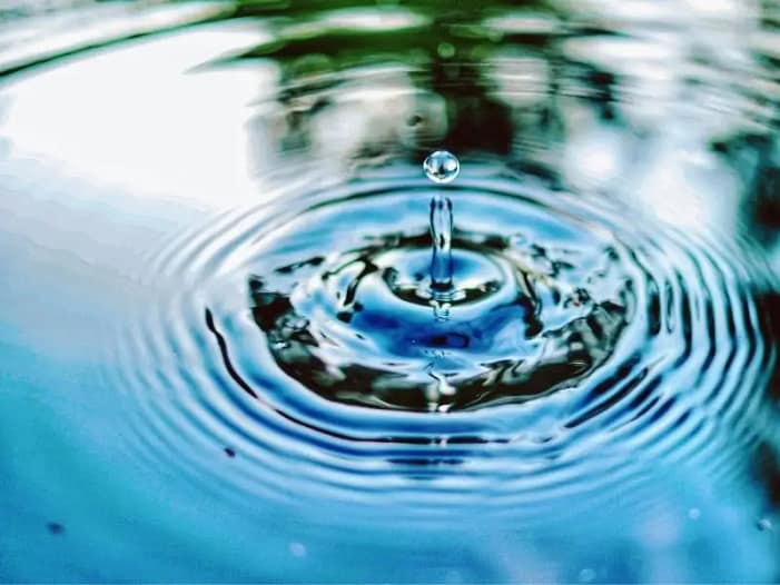 Wassertropfen erzeugt Wellenkreise - jede Äußerung ist ein Impuls ins Feld Wassertropfen fällt in stilles Wasser und erzeugt Wellenkreise - Symbol dafür dass jede Stimme und jede Äußerung Wirkung ins Feld entfaltet