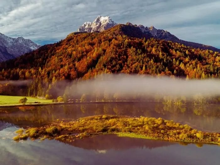 Mabon an der Schwelle zur dunkleren Jahreszeit Herbstliche Berglandschaft mit Nebel über einem See