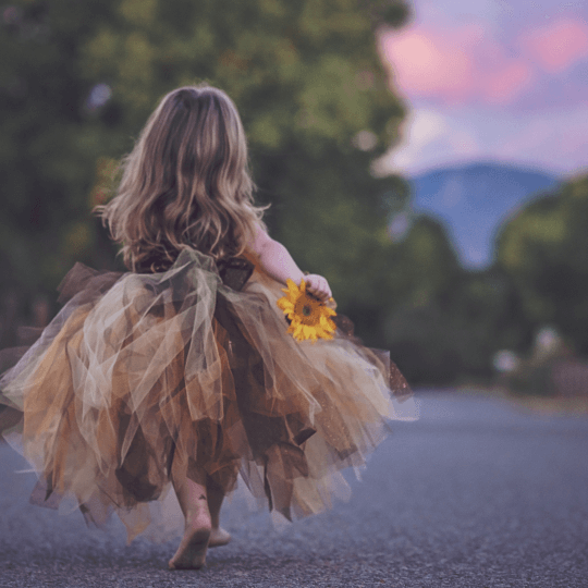 raum-fuer-mut-selbstvertrauen-selbstbewusst-unangepasst-fluegel-ausbreiten-wild-kreativität-rebellisch-grenzen-wachstum-mission-jana-engel Mädchen in Tüllrock mit Blume