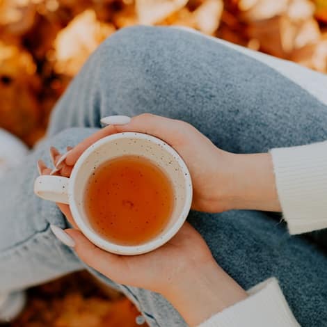 unverbindlicher-austausch-unterstuetzung-kaminzimmer-vertrauen-inspiration-selbstfindung-offenes-gespraech-herzlichkeit-entspannt-reden-jana-engel Frauenhände die Teetasse halten