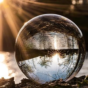akasha-chronik-seelenreisen-lesung-verbundenheit-selbstfindung-antworten-deutung-symbolik-integration-verwirklichung Glaskugel mit Spiegelung vor sonnenbeschienenem Fluss